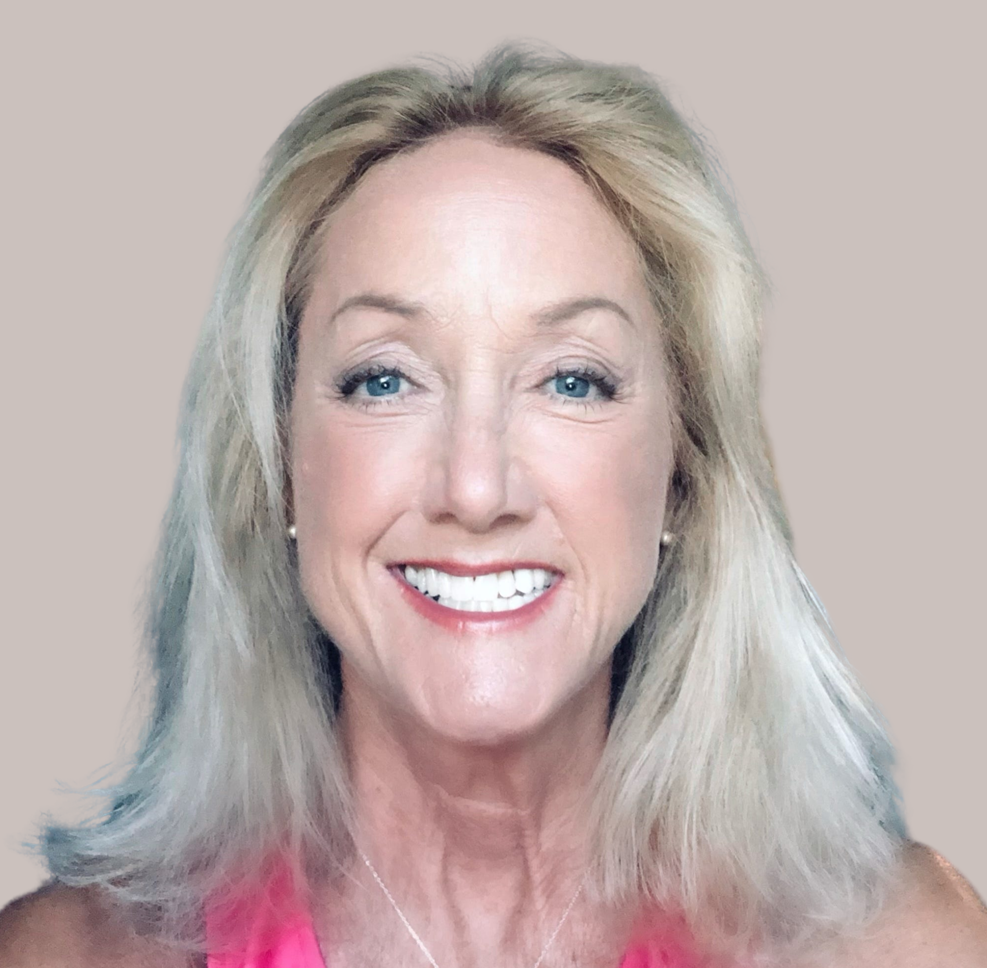 A middle-aged Caucasian woman with blonde hair is smiling '.', wearing a pink tank top and a small silver-colored necklace...